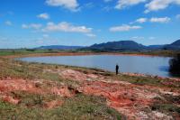 Aspecto do relevo do sítio da geodiversidade Buriol apresenta forte erosão como ravinas e sulcos, fica situada as margens de um açude. É uma área plana variando para um padrão de relevo suave ondulado e este afloramento fica localizado em meio a um grande setor utilizado para agricultura. (Autor: Michel Godoy/2008)