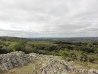 Topo do Rincão da Tigra onde observa-se no entorno conjunto de cerros e parte do vale fluvial do rio Camaquã compondo uma destacada paisagem geomorfológica. Aflora nesta porção do morro crista rochosa formada por  metarenitos e quartzitos de idade Neoproterozóica. Autor: Carlos Peixoto (2014)