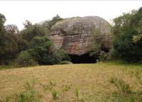 Entrada do Galpão de Pedra, grande bloco conglomerático tombado que gerou este abrigo sob-rocha. Fotografia: Carlos Peixoto, 2014.