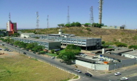 Fotografia da sede do Grupo Jaime Câmara com o Morro da Serrinha ao fundo, com torres de telecomunicação e reservatório de água. Fotografia reproduzida na reportagem Morro da Serrinha pode virar parque, em Goiânia, de Nielton Soares, publicada no Jornal O Hoje em 12/11/2019.